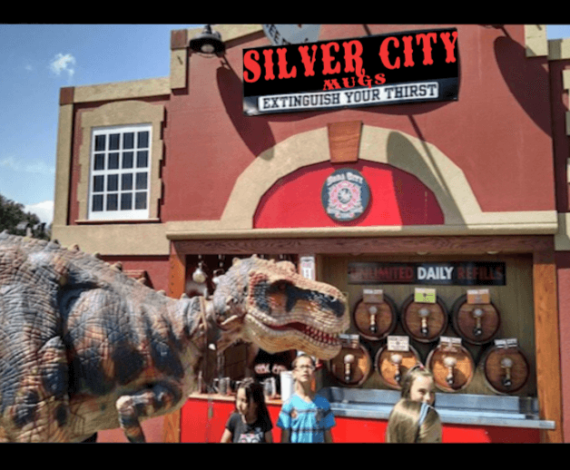 A t - rex in front of a silver city tavern.