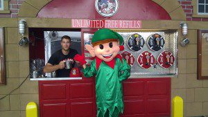 A man dressed as an elf is standing in front of a bar.