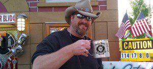A man in a cowboy hat holding a mug.